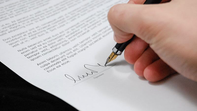 person signing a cremation / burial document