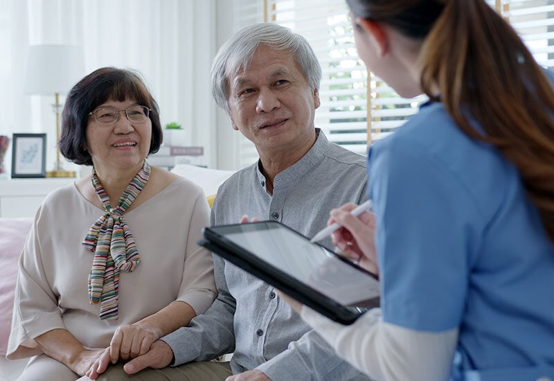 elderly couple talking with hospice inpatient care nurse