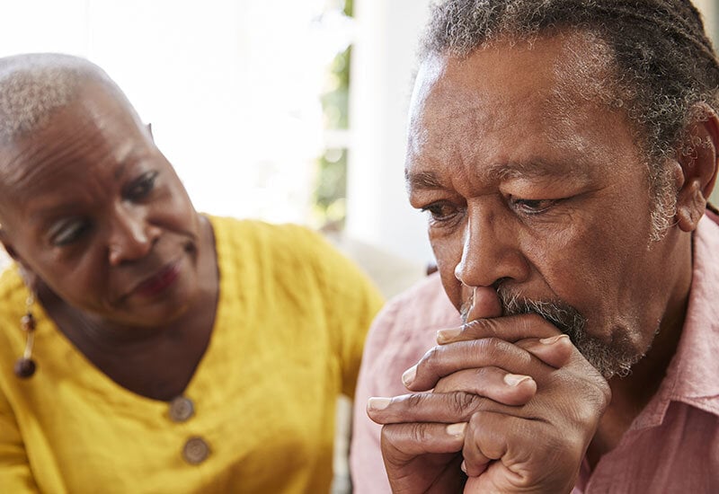 older woman consoling sad husband during after loss of family member