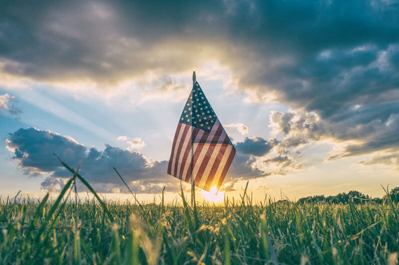 US flag in grass on a beautiful day at Los Angeles National Cemetery