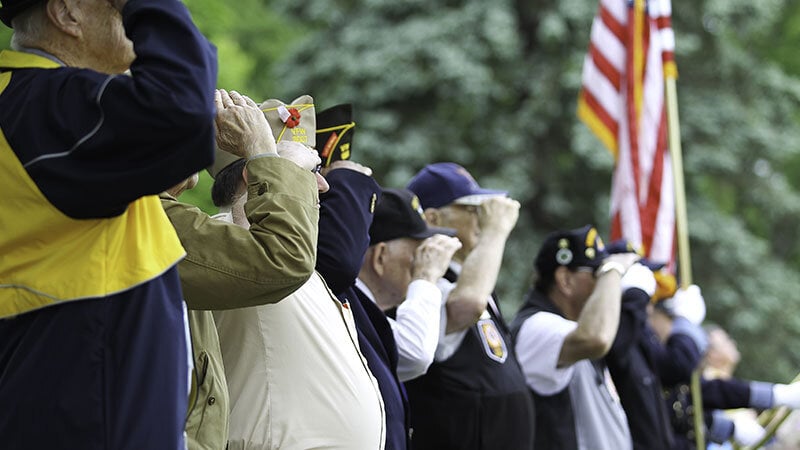 WWII veterans saluting fallen soldiers at funeral service at Riverside National Cemetery