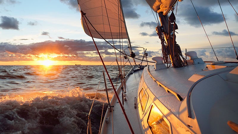 yacht sailing into the sunset off the coast of San Diego