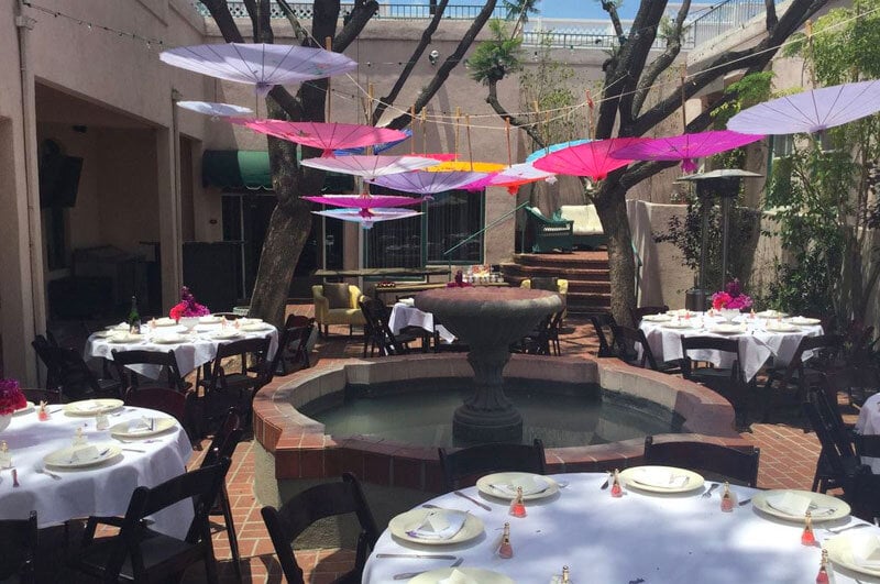outdoor private event seating by fountain, with hanging umbrellas at the mission square in los angeles