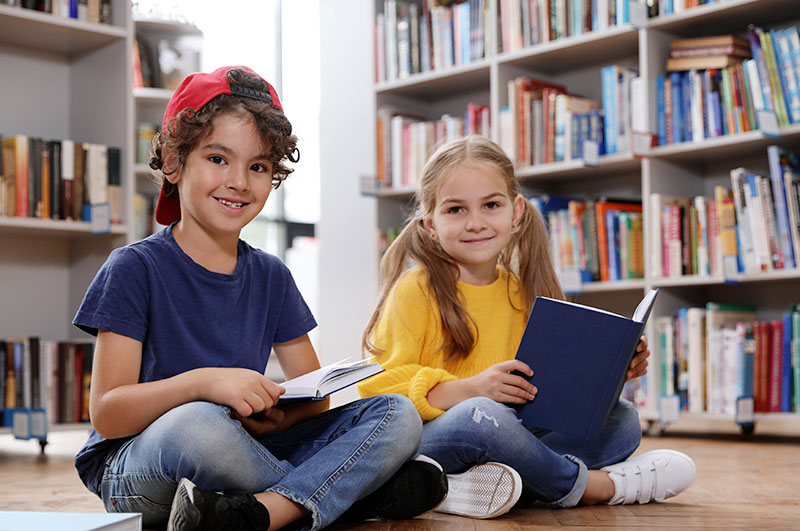 young kids reading books about coping with grief in library