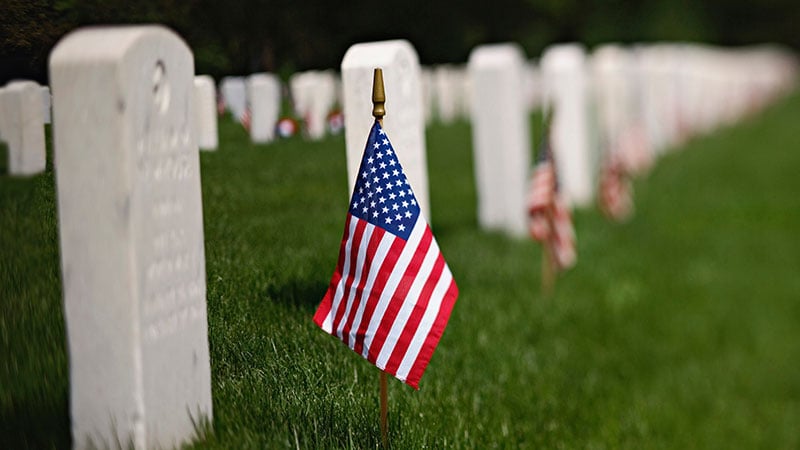 flag in front of gravestone at riverside national cemetery