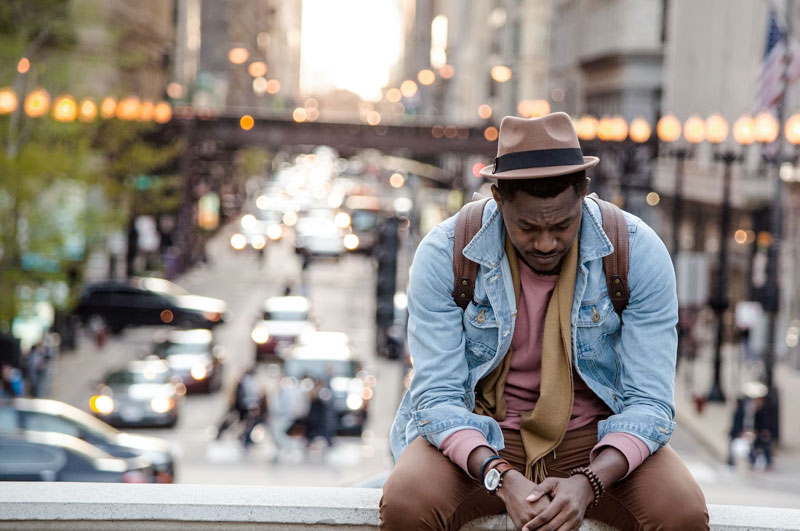 young man sitting in downtown los angeles, grieving for loss of loved one