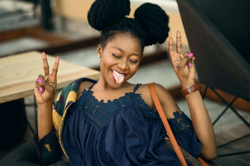 young woman giving peace signs while sticking tongue out at memorial service in los angeles