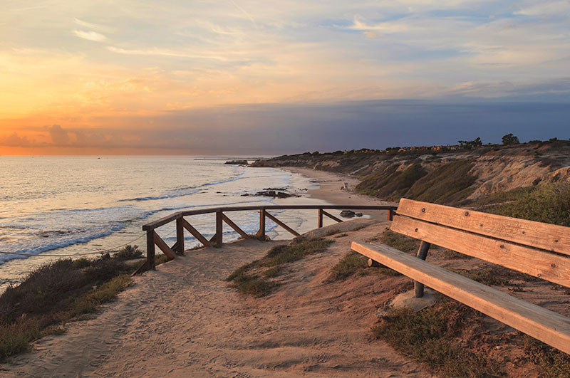 crystal cove state park and beach view at sunset, with bench, in Orange County, CA