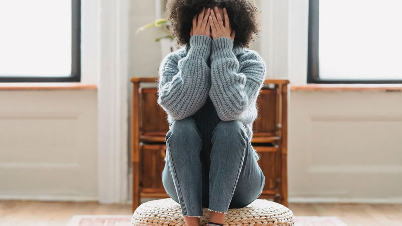 young woman with head in her hands experiencing grief or depression