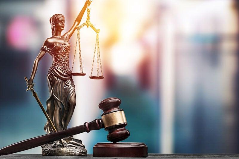 La Dama de la Justicia con una espada en una mano y una balanza en la otra, simbolizando la imparcialidad, la justicia y el poder de la ley.