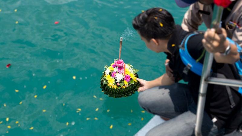 Family member places cremated remains of loved one in the Pacific Ocean off of Los Angeles County during an ash scattering ceremony