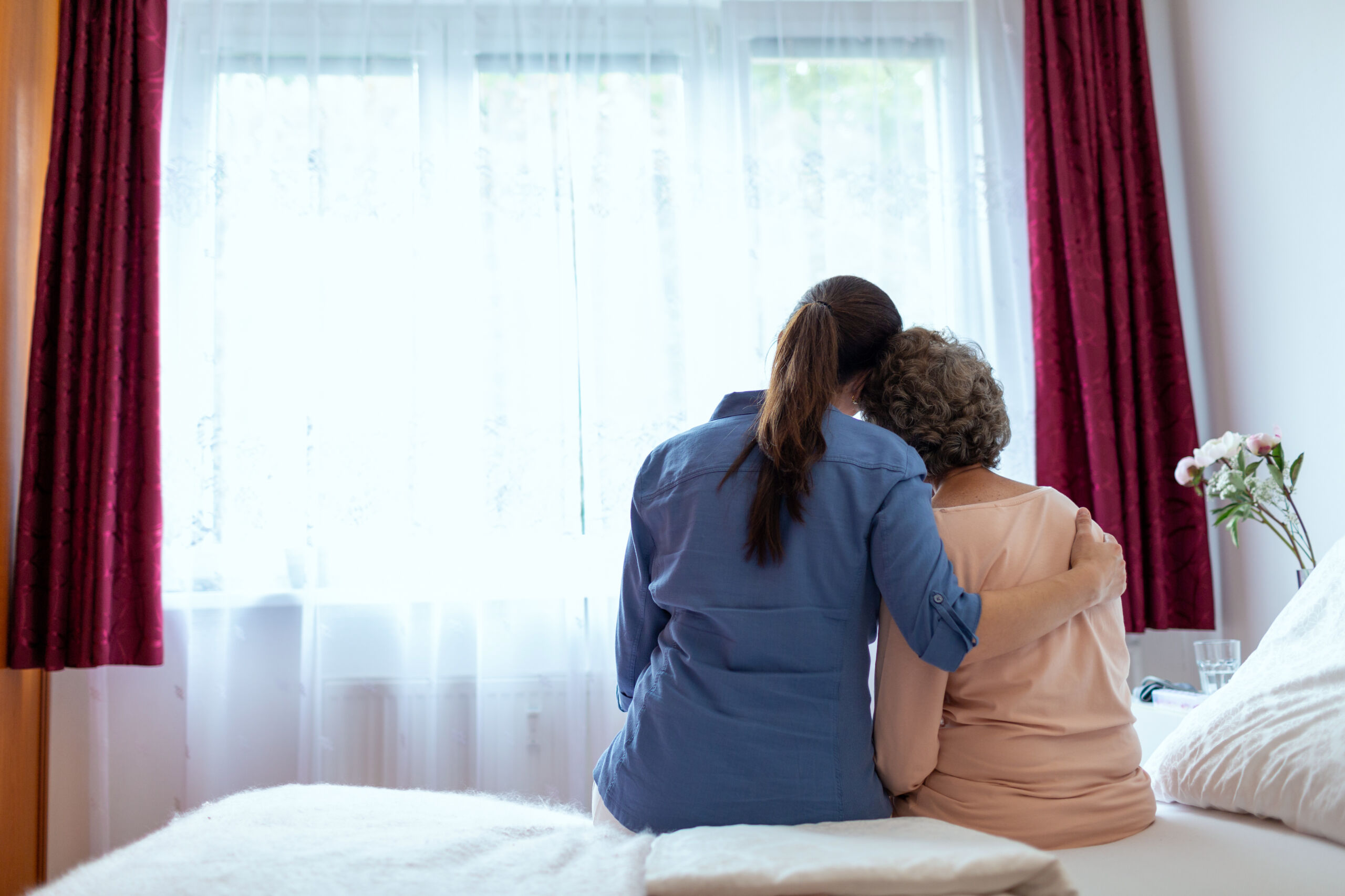 Relative hugs an elderly woman as she says goodbye