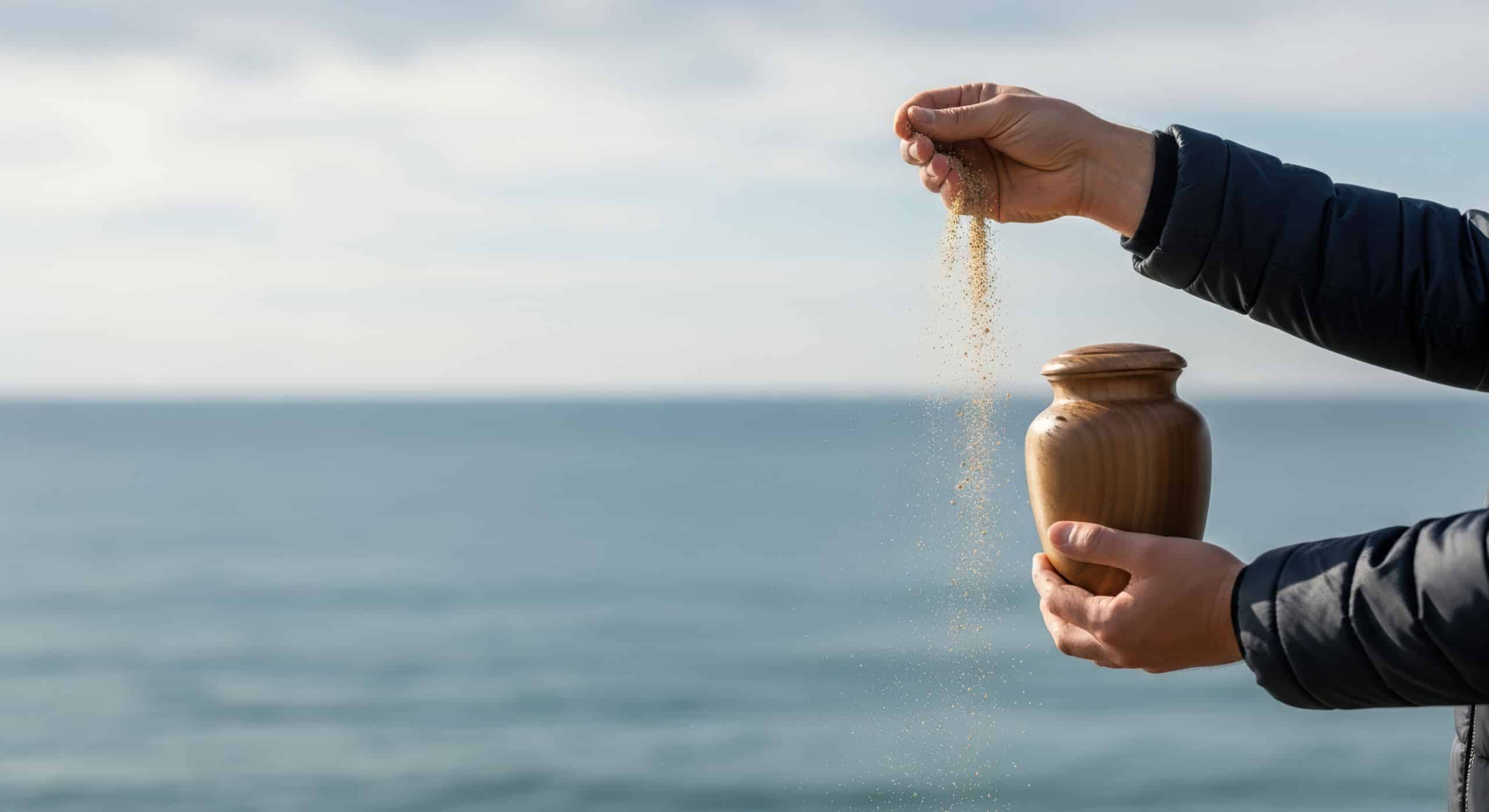 man scatters ashes at sea
